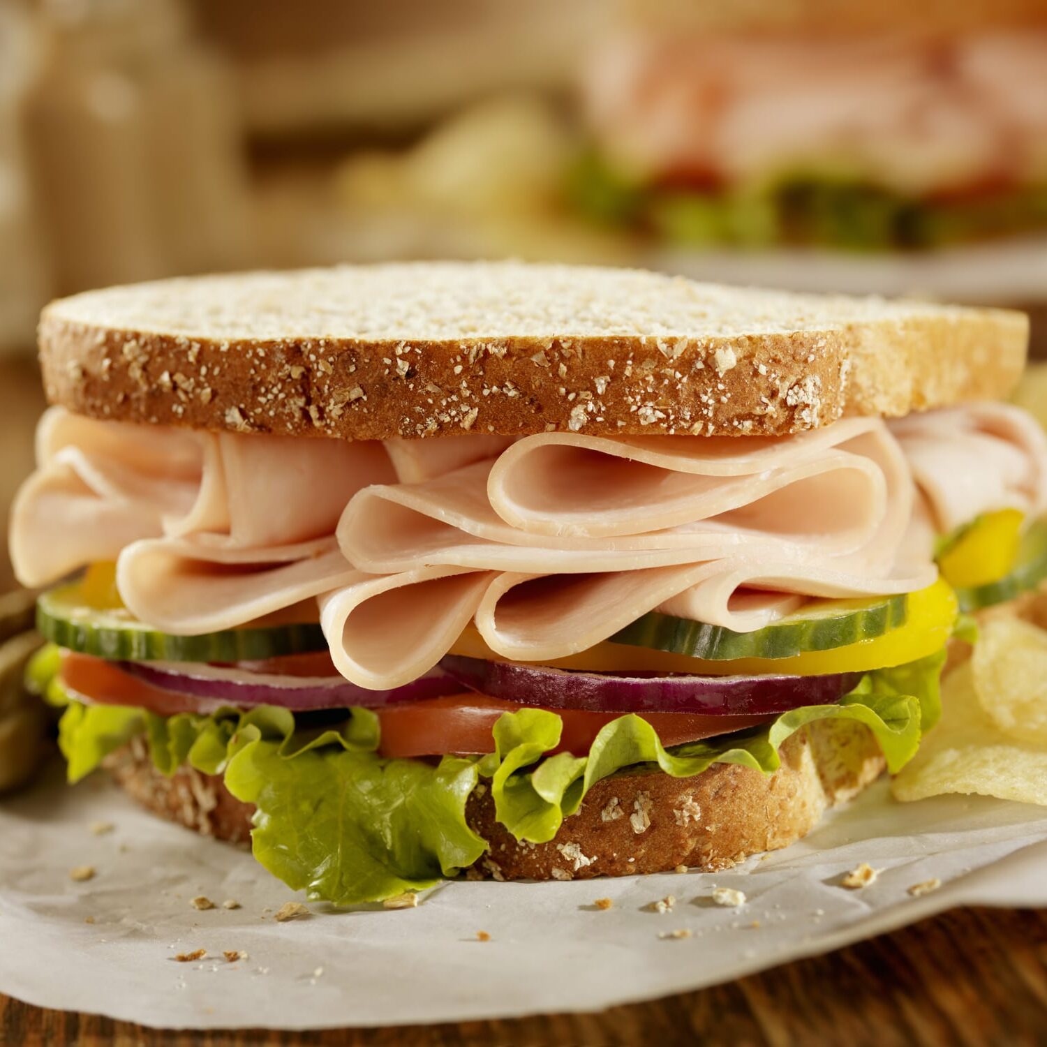 "Smoked Turkey Sandwich on Whole Grain Bread with Lettuce, Tomatoes, Cucumbers, Red Onions, Yellow Peppers and Potato Chips on the Side- Photographed on Hasselblad H3D2-39mb Camera"